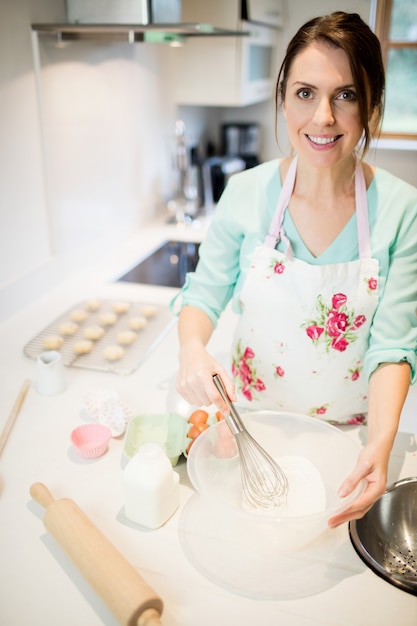 Free photo woman whisking flour in bowl