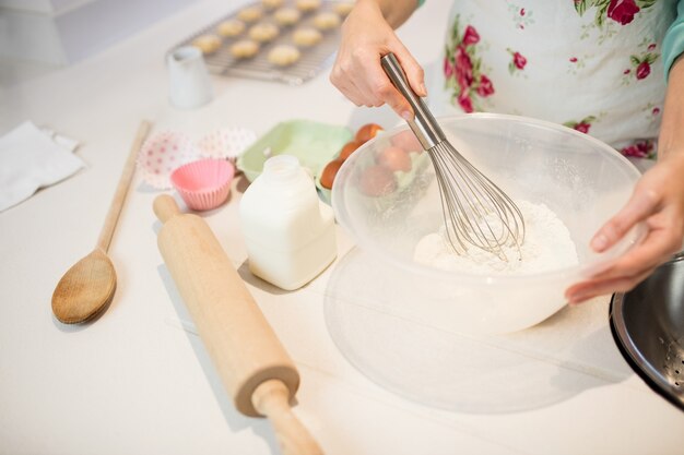 Woman whisking flour in bowl