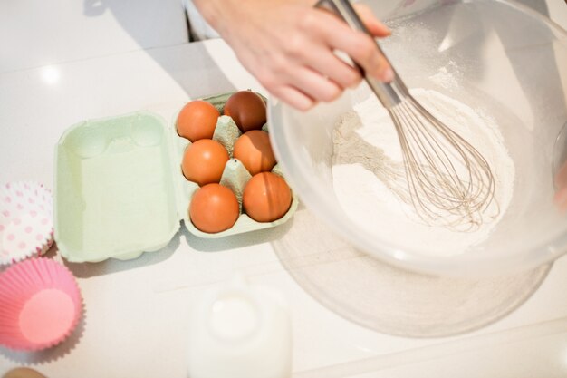 Woman whisking flour in bowl