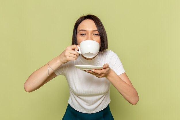 woman in white blouse and green skirt drinking tea 