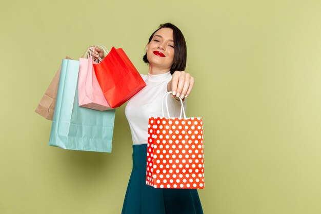 woman in white blouse and green skirt holding shopping packages