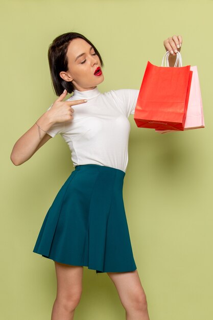 woman in white blouse and green skirt holding shopping packages 