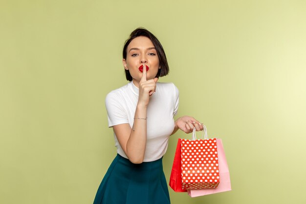 woman in white blouse and green skirt holding shopping packages 