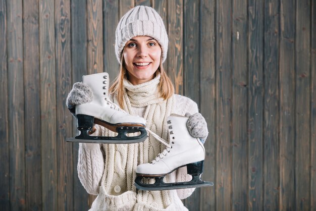 Woman in white cap holding skates