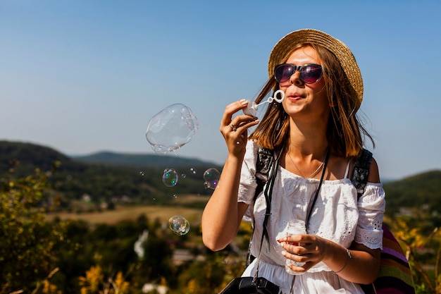 Woman in white dress making soap bubbles