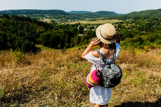 Free photo woman in white dress taking a photo of the forest