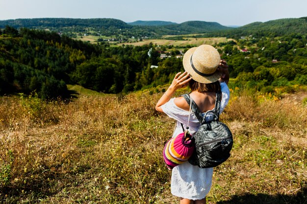 Woman in white dress taking a photo of the forest