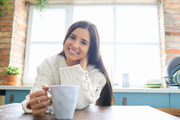 Woman in white knit sweater at home