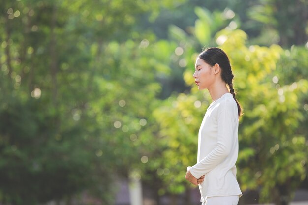Free Photo woman in white outfit meditating in nature