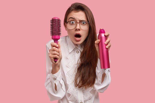 Woman in white shirt styling her hair