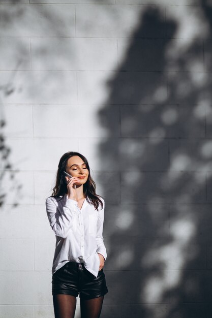 Woman in white shirt talking on the phone