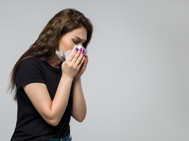 Woman in white sterile medical protective mask wiping her nose