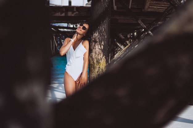 Woman in white swimming suit by the ocean