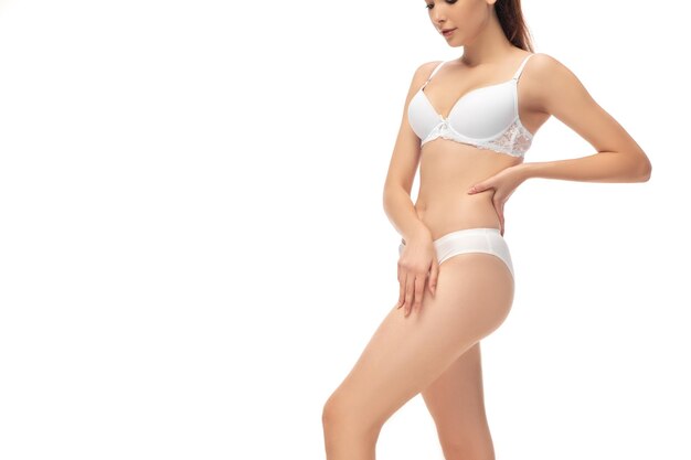Woman in white underwear posing on white