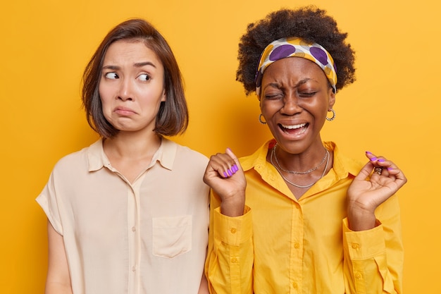 Foto gratuita donna che ha un'espressione dolente alza le mani e si sente turbata esprime emozioni negative dopo che è successo qualcosa di spiacevole isolato su giallo