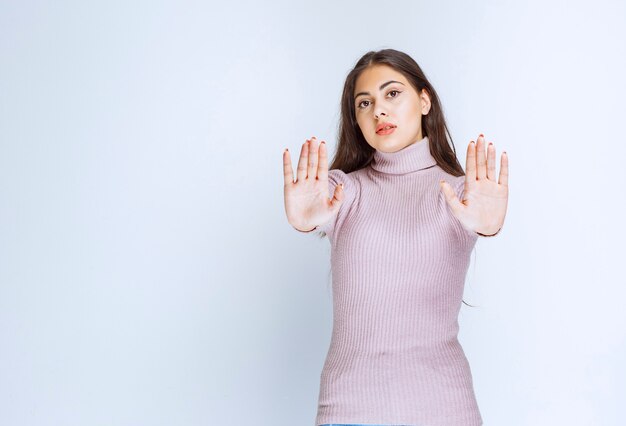 手を大きく開いて何かを止める女性。