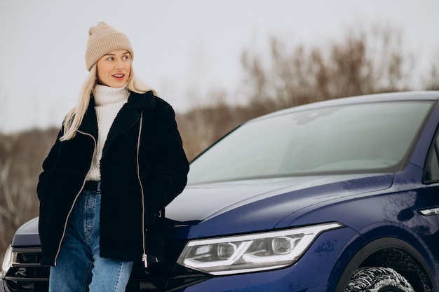 Woman in winter cloths standing by her car