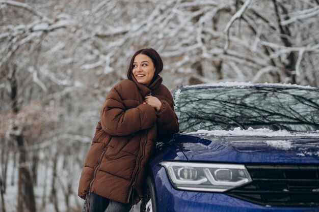 Женщина в зимнем лесу на своей машине