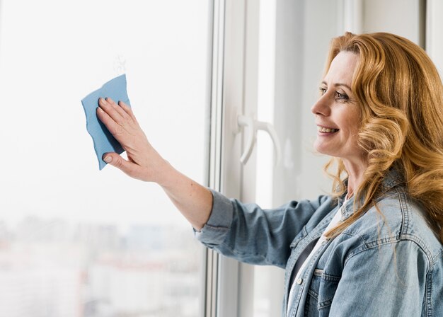 Woman wiping window with rag