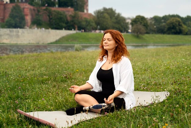 Woman wit prosthetic leg doing yoga