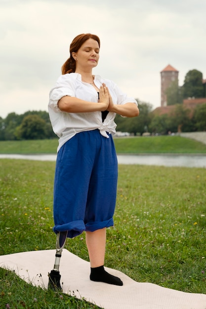 Foto gratuita donna con gamba protesica che fa yoga