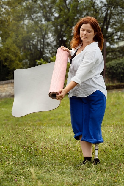 Woman wit prosthetic leg doing yoga