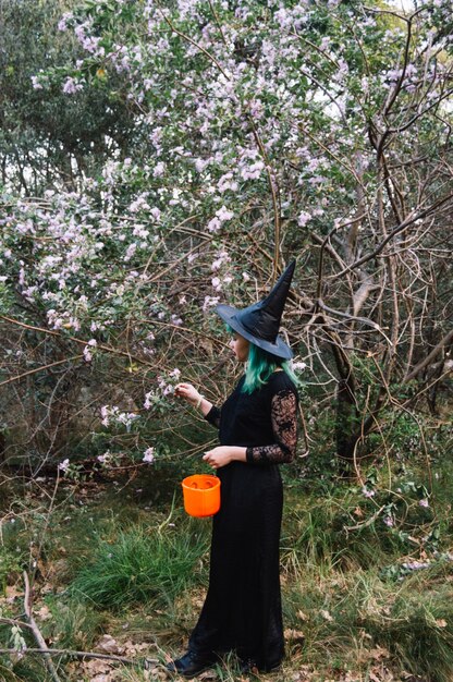 Free photo woman witch at flowered tree