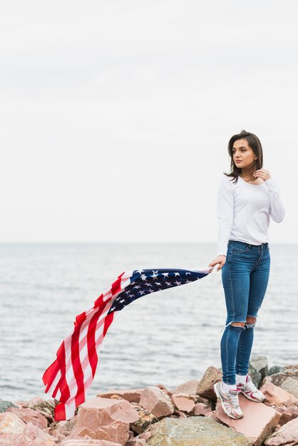 Женщина с американским флагом у моря