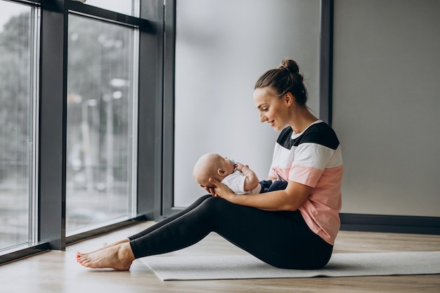 Donna con yoga di pratica del neonato