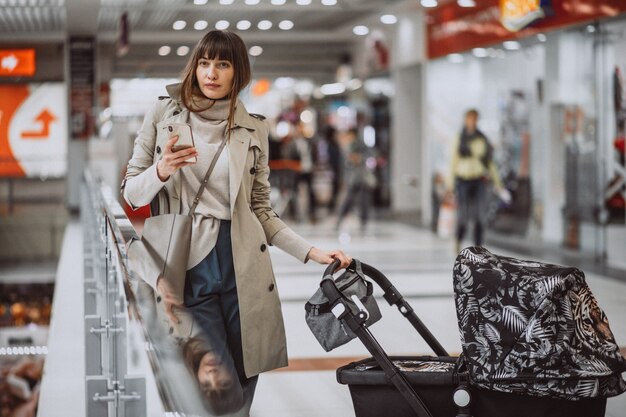 Woman with baby carriage in shopping mall