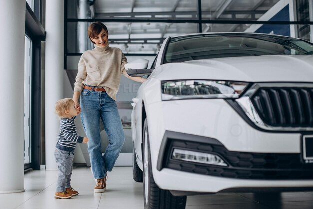 カーサロンで車を選ぶ赤ん坊の息子を持つ女性