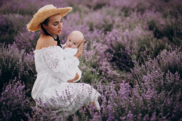 Foto gratuita donna con figlio neonato in un campo di lavanda