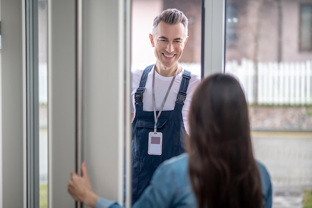 Woman with back to camera opening door to man