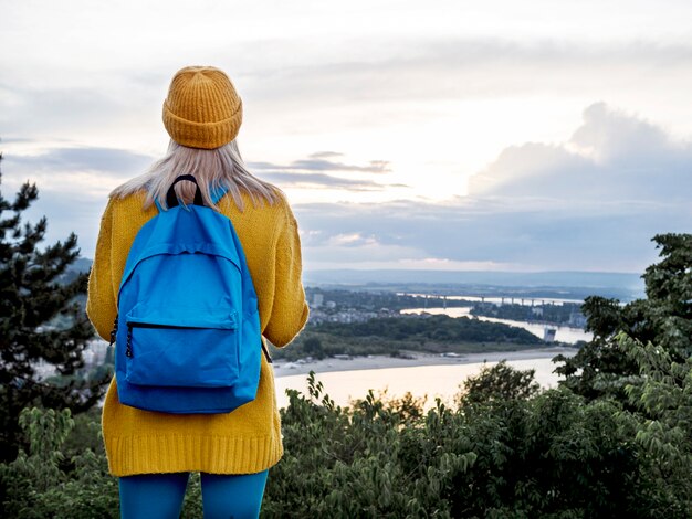 Woman with backpack admiring mountain view