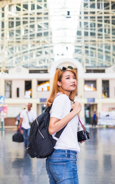 Бесплатное фото Женщина с рюкзаком и камерой на железнодорожной станции