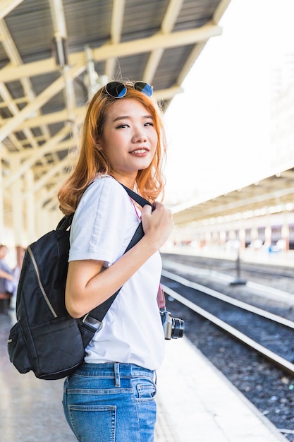 Woman with backpack and camera on platform