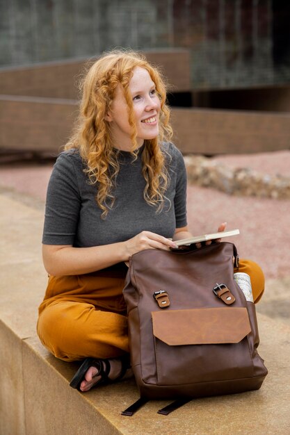 Woman with backpack holding journal