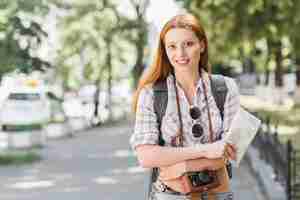 Бесплатное фото Женщина с картой и камерой рюкзака
