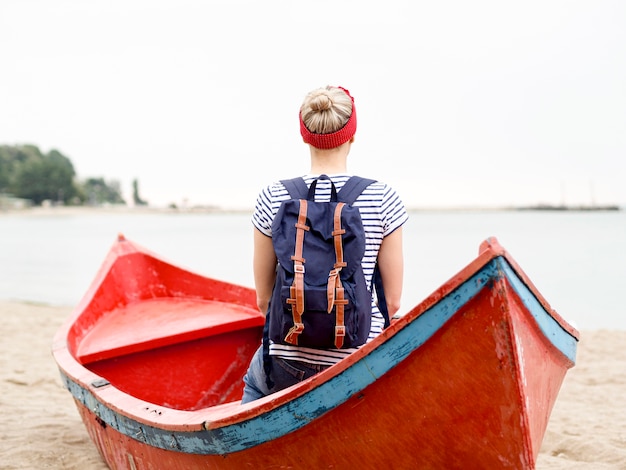 ボートで旅行のバックパックを持つ女性