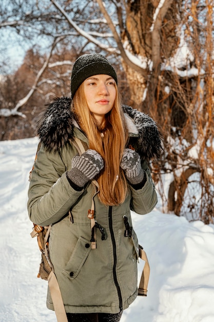 Foto gratuita donna con zaino in giornata invernale