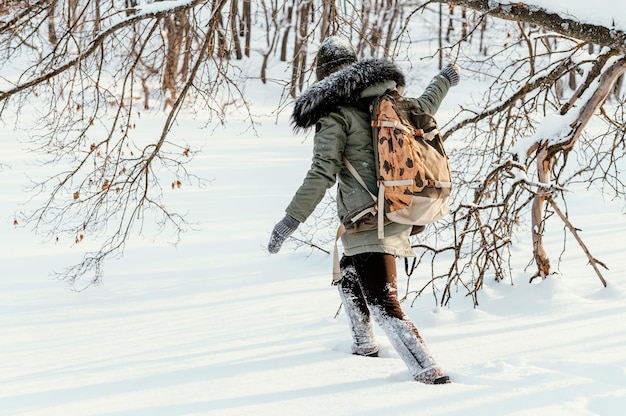 Foto gratuita donna con zaino in giornata invernale