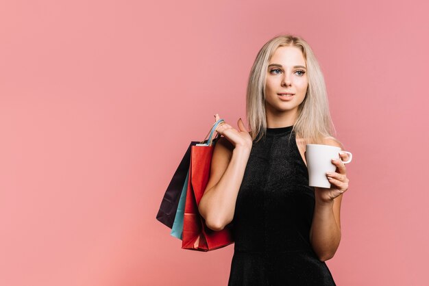 バッグとカップを持つ女性