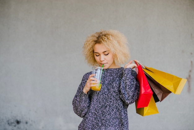 Foto gratuita donna con sacchetti bere