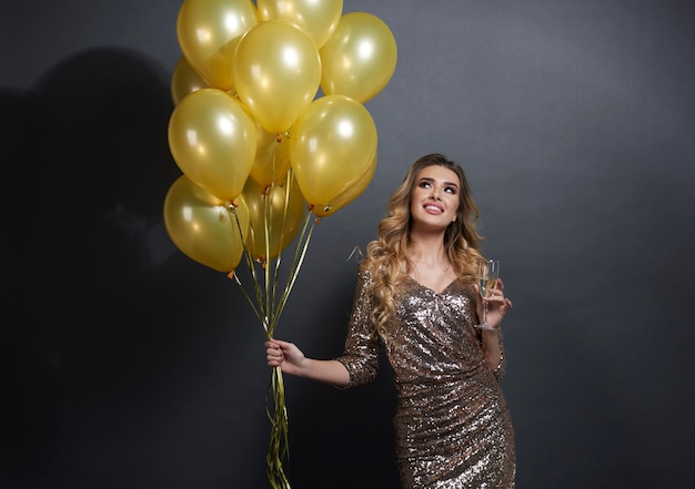 Foto gratuita donna con palloncini e champagne alzando lo sguardo