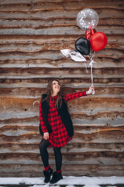 Woman with balloons on her birthday outside