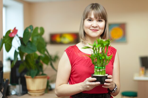 竹の植物を持つ女性