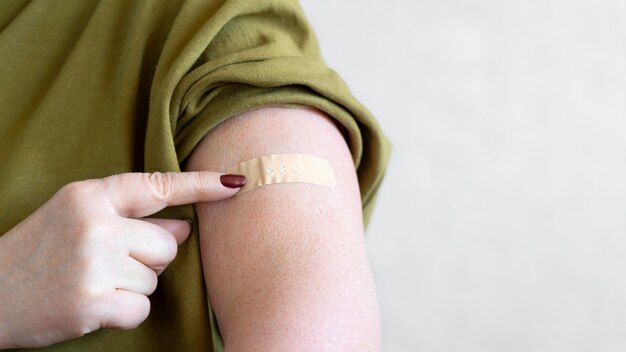 Woman with bandage on arm after vaccination