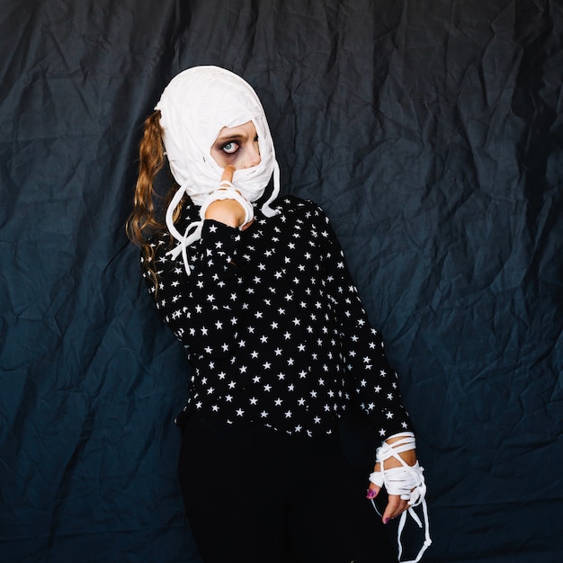 Woman with bandaged face and hands posing 