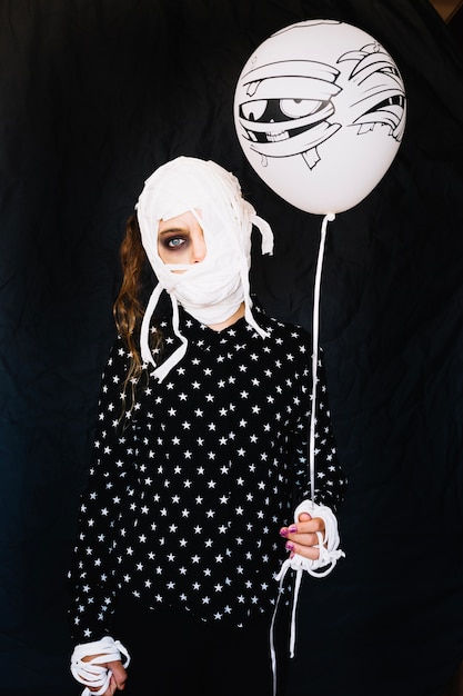 Free photo woman with bandaged face holding balloon