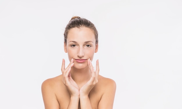 Woman with bare shoulders touching face